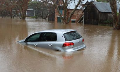 Une voiture sous les eaux lors de l'inondation d'une petite ville pour évoquer la force majeure et l'inexécution d'un contrat.